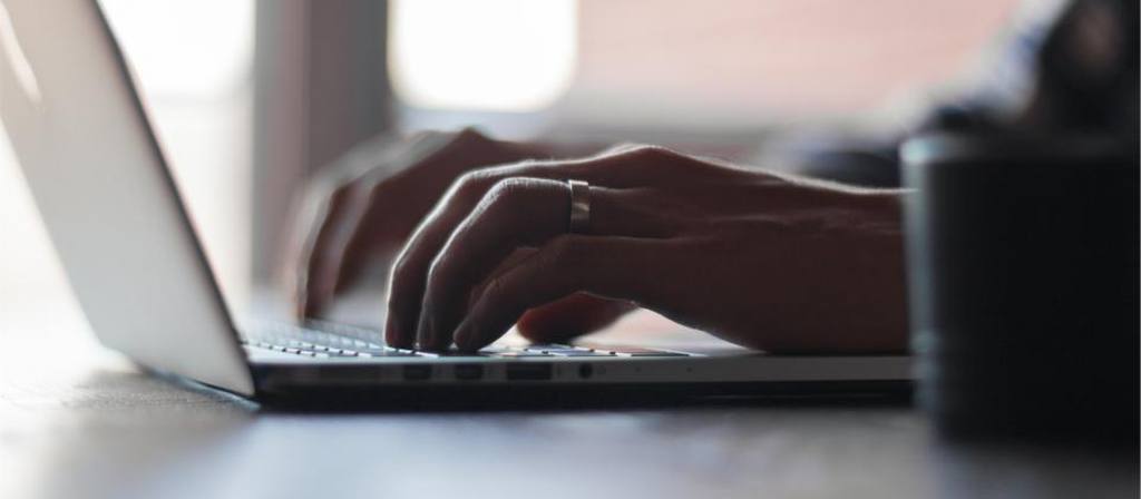 Mains tapant sur un clavier d'ordinateur portable