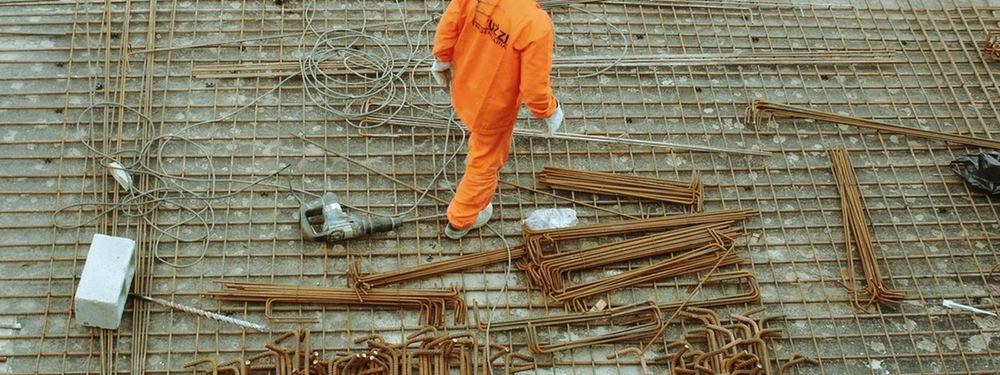 Ouvrier en combinaison orange sur un chantier de ferraillage